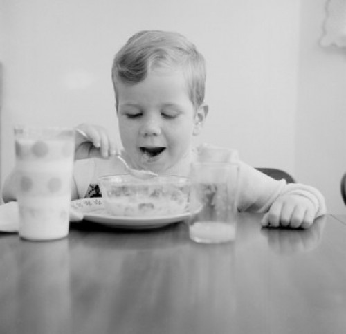 Boy eating breakfast cereal Poster Print