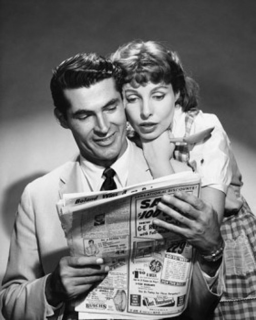 Young couple reading a newspaper Poster Print - Item # VARSAL25541430