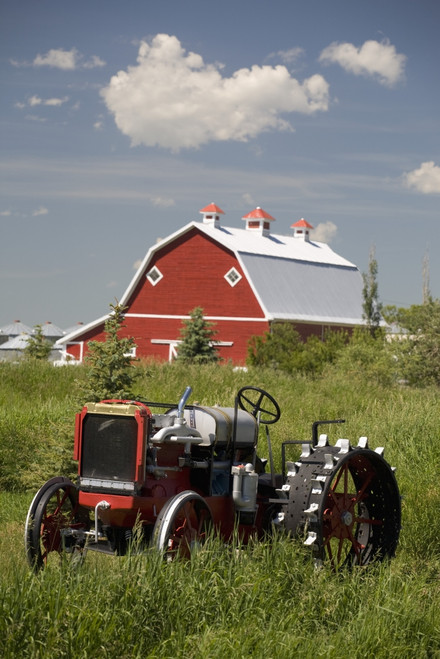 Old Red Tractor In A Field With A Red Barn In The Background; Alberta, Canada PosterPrint - Item # VARDPI1882122