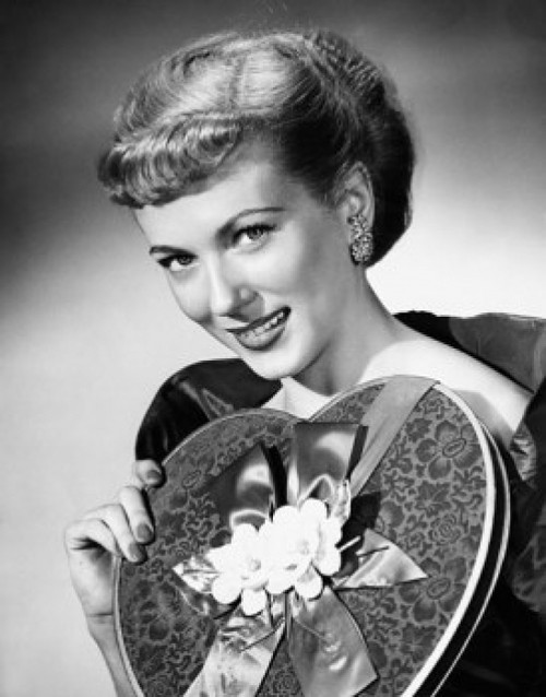 Portrait of a young woman holding a Valentine gift and smiling Poster Print - Item # VARSAL25528931