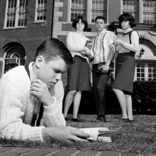 Students watching friend reading on grass outside university Poster Print - Item # VARSAL255418380