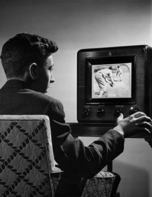 Young man changing channels of a television Poster Print - Item # VARSAL2551658