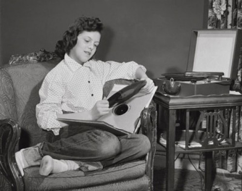 Teenage girl sitting in armchair and holding record Poster Print - Item # VARSAL2552590 Teenage girl sitting in armchair and holding record Poster Print - Item # VARSAL2552590