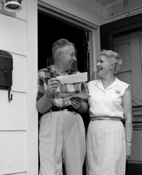 Smiling senior couple standing at front door  holding letters Poster Print - Item # VARSAL25548920