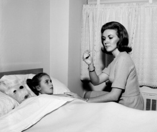 Mother checking daughter's temperature in bed Poster Print - Item # VARSAL255417755