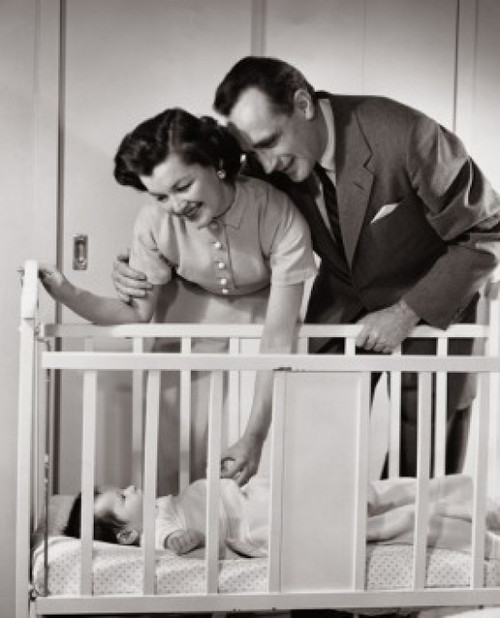 Parents looking at their baby lying in a crib Poster Print - Item # VARSAL2559757