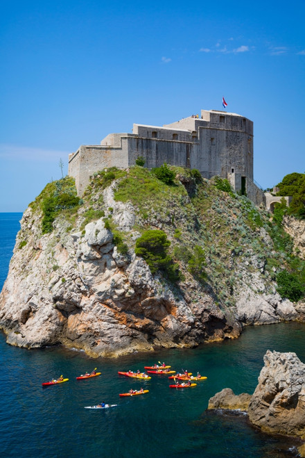 Dubrovnik, Dubrovnik-Neretva County, Croatia. Fort Lovrijenac or St. Lawrence Fortress. Canoeists in harbour. The old city of Dubrovnik is a UNESCO World Heritage Site. Poster Print by Panoramic Images - Item # VARPPI170119