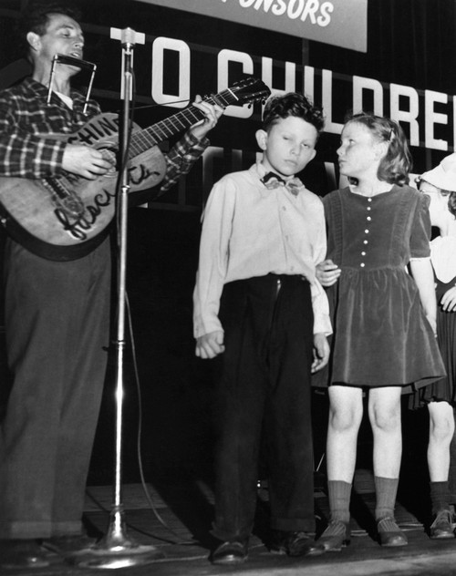 Woody Guthrie (1912-1967). /Namerican Folk Singer, Leading Children In Song At A United Nations Event For Children, 1948. Poster Print by Granger Collection - Item # VARGRC0168761