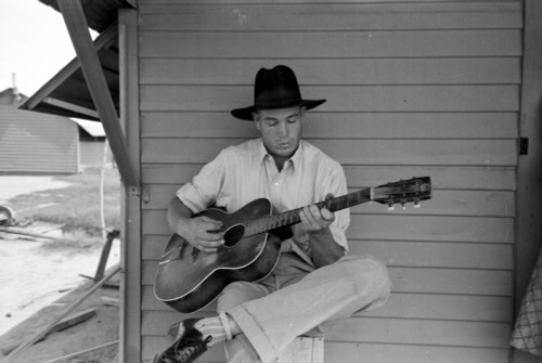 Migrant Worker, 1940. /Na Migrant Worker Playing Guitar In The Agua Fria Labor Camp, Arizona. Photograph By Russell Lee, 1940. Poster Print by Granger Collection - Item # VARGRC0352001