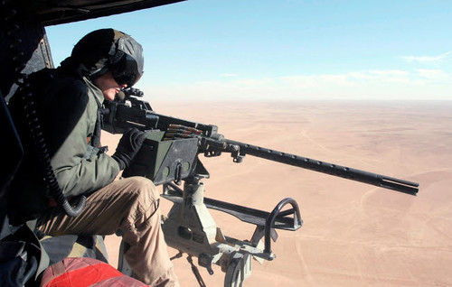 US Marine checks out the GAU-16/A Cal 50 machine gun onboard his UH-1N Huey helicopter Poster Print by Stocktrek Images - Item # VARPSTSTK101362M