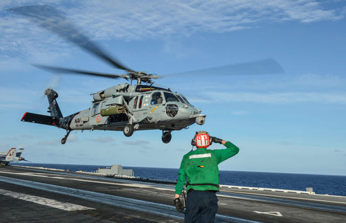 Airman salutes as a MH-60S Sea Hawk helicopter departs Poster Print by Stocktrek Images - Item # VARPSTSTK108338M