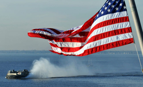 American flag blowing in the wind with a hovercraft in the background Poster Print by Stocktrek Images - Item # VARPSTSTK104602M