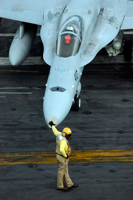 Flight Deck Officer monitors the movement of flight deck personnel from the nose of an F/A-18C Hornet Poster Print by Stocktrek Images - Item # VARPSTSTK100090M