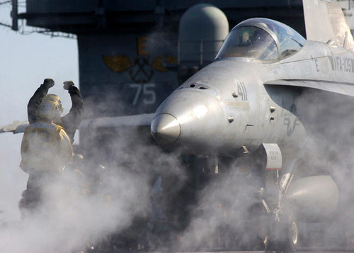 Flight deck personnel perform final checks on an F/A-18C Hornet prior to launch Poster Print by Stocktrek Images - Item # VARPSTSTK100754M