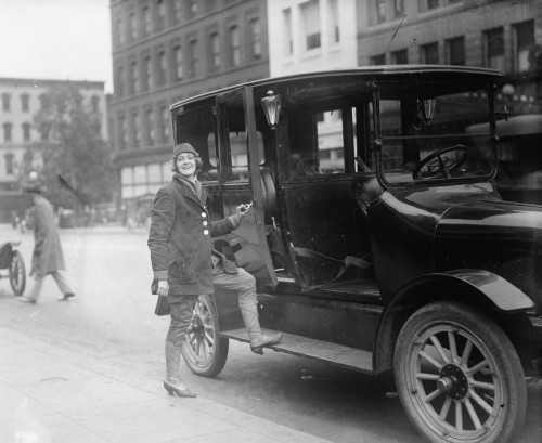 A woman driver holds a door open to a taxi Poster Print - Item # VARBLL058748737L