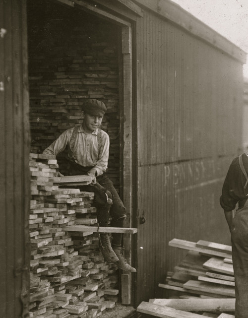 Young boy working for Hickok Lumber Co. Unloading wood from a boxcar Poster Print - Item # VARBLL058754397L