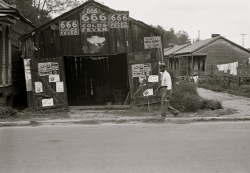 African American walks in front of, Advertisements for popular malaria cure, Natchez, Mississippi Poster Print - Item # VARBLL058744879L
