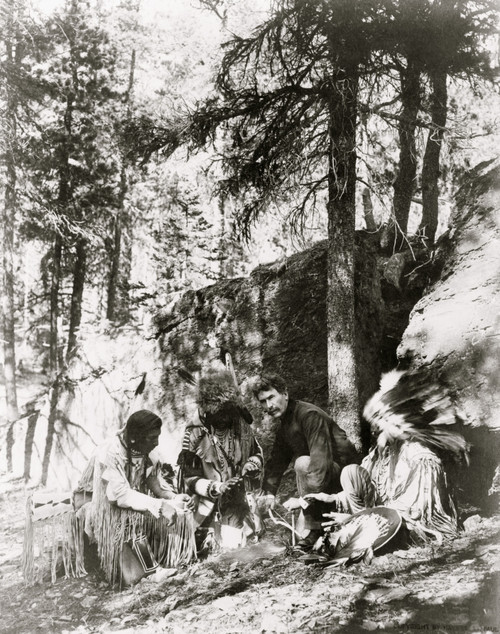 Ernest Thompson Seton, with three Blackfeet Indians, demonstrating how to start a fire using a bow and a stick, rocks and trees in background Poster Print - Item # VARBLL058751274L