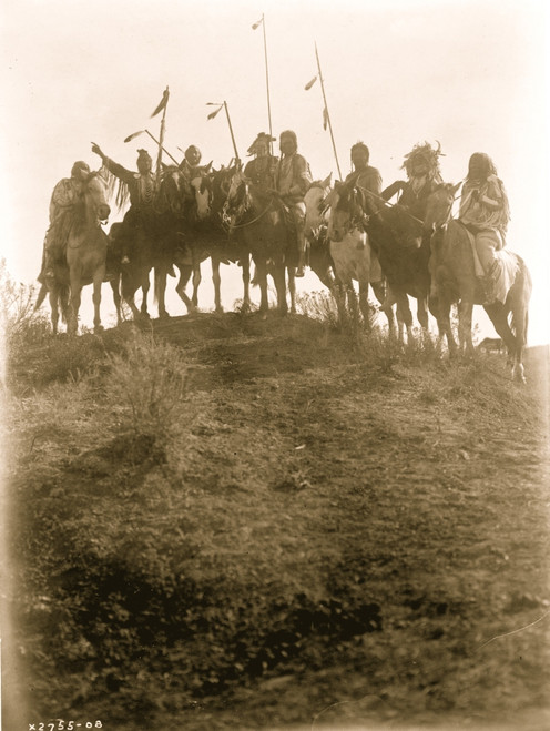 Eight Crow Indians on horseback, silhouetted on top of hill, man second from left is pointing, Montana. Poster Print - Item # VARBLL058747563L