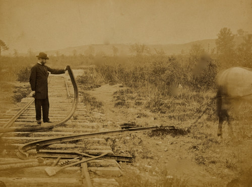 Military railroad operations in northern Virginia: man standing on railroad tracks holding twisted rail Poster Print - Item # VARBLL058745502L