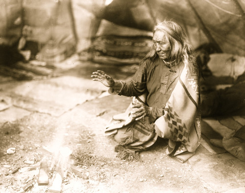 Navajo Indian warming hands over fire in tepee. Poster Print - Item # VARBLL058751185L