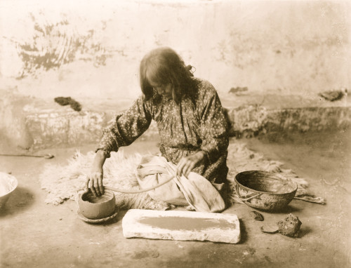 Zuni woman kneeling on animal skin on floor, making pottery. Poster Print - Item # VARBLL058747598L