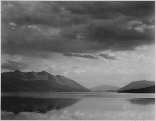 Looking across lake to mountains and clouds "Evening McDonald Lake Glacier National Park" Montana. 1933 - 1942 Poster Print by Ansel Adams - Item # VARBLL0587400455