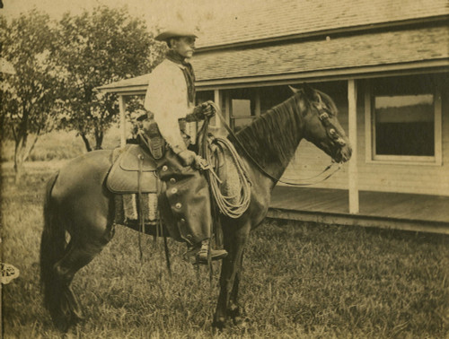 Cowpoke On The Ranch, Circa 1890S.- Posed Near The Front Porch Of A Ranch House. His Heavy Leather Chaps Sport Silver Conches Down The Side, And He Holds His Pistol At The Ready. Poster Print - Item # VARBLL0587402679