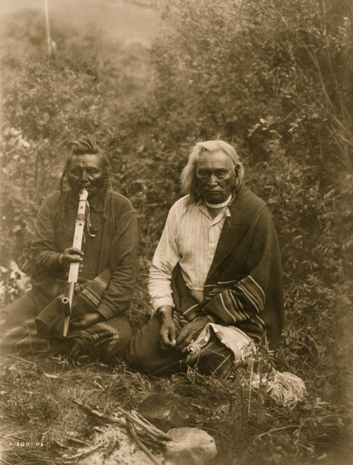 Two Crow Indians in Montana, sitting on the ground, one is smoking a pipe. Poster Print - Item # VARBLL058747735L