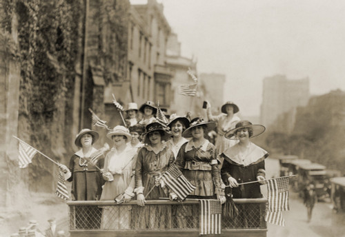 Smiling Young Women Waving Flags From The Top Of An Open Vehicle In A New York City Parade. Ca. 1910-1915. History - Item # VAREVCHISL017EC165