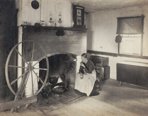Olden Times. Middle Aged Woman Watching Her Cooking From A Rocking Chair By A Fireplace As She Smokes A Pipe. Photograph Made In 1900 History - Item # VAREVCHISL020EC046