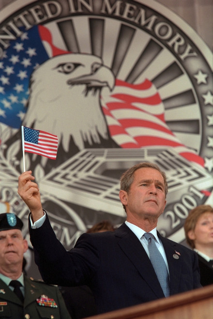 President George W. Bush At Remembrance Service For The 9-11 Victims At The Pentagon. Behind Bush 43 Is An Elaborate Backdrop With An Eagle And He Holds Up A Small American Flag. Oct. 11 History - Item # VAREVCHISL039EC926