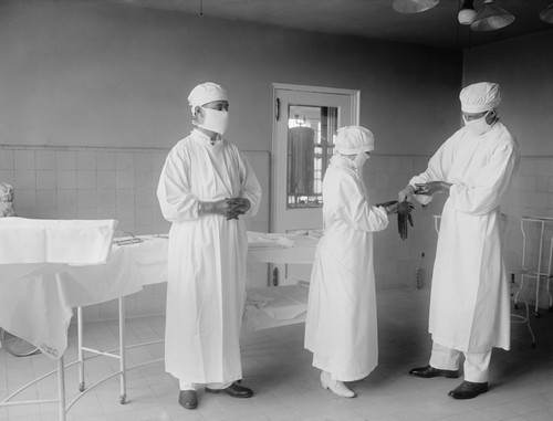 Surgical Nurse Assists Surgeons Into Rubber Gloves Before An Operation. 1922 In A Hospital In Washington History - Item # VAREVCHISL043EC210