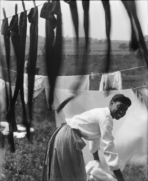 A Young African American Woman Working In The Midst Of Clotheslines Heavy With Sheets And Stockings History - Item # VAREVCHCDLCGBEC125