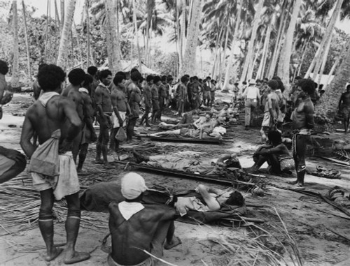 New Guinean Native Stretcher Bearers Pause In Their Transport Of American Wounded. They Rest Themselves And The Soldiers In The Shade Of A Coconut Grove History - Item # VAREVCHISL036EC542