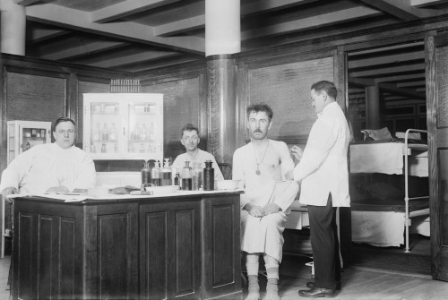 Two Recently Bathed Men Are Given Vaccinations By The Doctor At New York City'S Municipal Lodging House. Ca. 1910. History - Item # VAREVCHISL008EC181