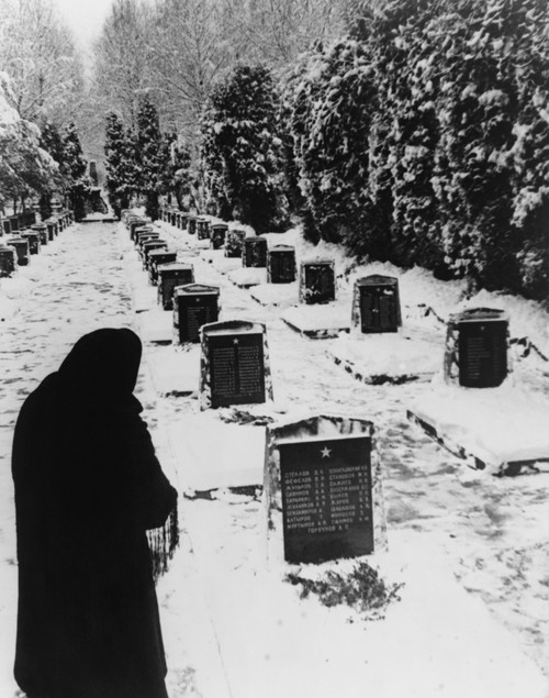 Russian Woman In A Snow-Covered Military Cemetery. World War 2 Soviet Tombstones Are Inscribed With Several Names. Unknown Location. 1945 Photo By Yevgeny Khaldei. History - Item # VAREVCHISL036EC565