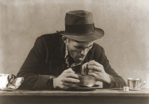 Hungry Man With His Meal Of Bread And Soup At A New York City Soup Kitchen During The Great Depression. His Fedora And Now Ragged Sports Jacket Indicate His Past Employment. 1930S. History - Item # VAREVCHISL019EC190