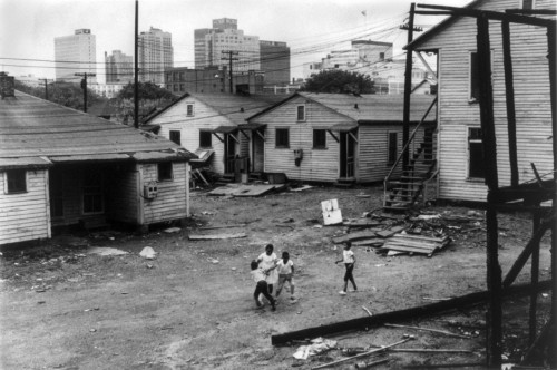 African American Children Playing In Slum In View Of High Rise Buildings In Background. North Carolina History - Item # VAREVCHISL019EC162