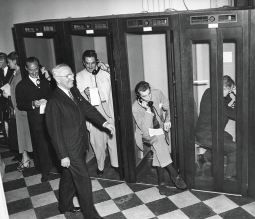 President Harry Truman Walks Past Reporters In The Telephone Booths The Old State Department Building. They Are Reporting Back To Their Headquarters After Truman'S Press Conference History - Item # VAREVCHISL039EC996
