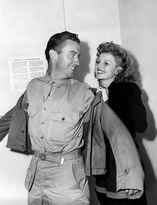 Rita Hayworth Helps A Lucky Soldier Into His Jacket At The Hollywood Canteen History - Item # VAREVCPBDRIHAEC100