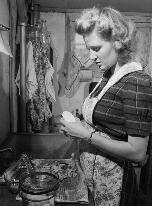 Young Women Peeling Potatoes In Her Washington D.C. Apartment Kitchen. She Has A Modern Glass Cooking Pot And Uses A Newspaper To Collect The Potato Peels For The Garbage. Dec. 1943. History - Item # VAREVCHISL033EC199