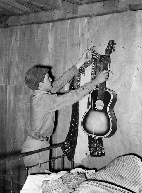 Migrant Worker, 1939. /Na Young Migrant Worker Takes His Guitar Down From The Wall At His Home In Muskogee, Oklahoma, Before He And His Family Leave For California. Photograph By Russell Lee, July 1939. Poster Print by Granger Collection - Item # VAR Migrant Worker, 1939. /Na Young Migrant Worker Takes His Guitar Down From The Wall At His Home In Muskogee, Oklahoma, Before He And His Family Leave For California. Photograph By Russell Lee, July 1939. Poster Print by Granger Collection - Item # VAR