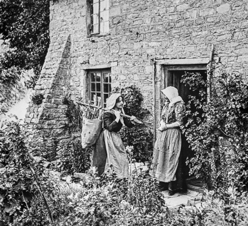 Historical image of two women standing outside a stone house talking at the doorway, one coming to sell her wares Poster Print by John Short / Design Pics - Item # VARDPI12512086