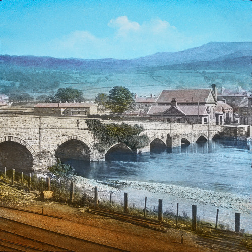Magic Lantern slide circa 1900 hand coloured created 1887 A tour North WalesDolgellau 42 Dolgelly BridgeThis view presents peculiar shaped bridgeover river Wnionwhich owes its irregular form alterations made carrying it over railway town has long be