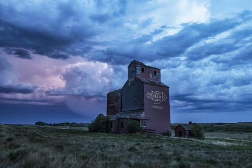 Weathered grain elevator and storm on the prairies; Saskatchewan, Canada Poster Print by Robert Postma # 12577834