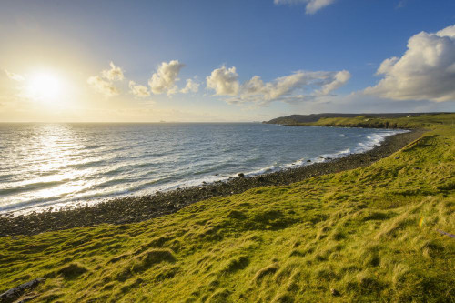 Rocky coastal beach with sun shining over the ocean on the Isle of Skye in Scotland, United Kingdom Poster Print by Raimund Linke (20 x 13)