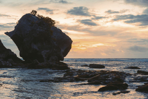 Silhouette of large rock formation and coastline of Diamond Beach at twilight, Nusa Penida, Bali, Indonesia; Nusa Penida, Bali, Indonesia Poster Print by O'Neil Castro (19 x 12)