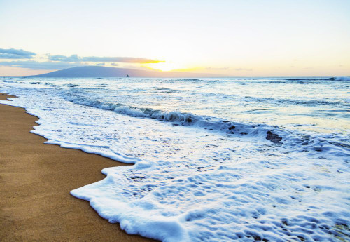 The sea surf foams as it rolls onto a beach with a view of the Island of Lanai and clouds in the distance at sunset; Ka'anapali, Maui, Hawaii, United States of America Poster Print by LJM Photo (18 x 12)