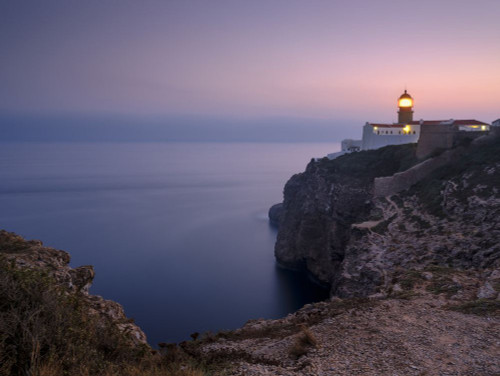 A lighthouse in Portugal at sunset. Poster Print by Loop Images Ltd. (18 x 14)